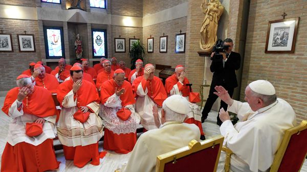 This photo taken and handout on August 27, 2022 by The Vatican Media shows Pope Francis (R) and Pope Emeritus Benedict XVI (C) meeting with new Cardinals following a consistory to create 20 new cardinals in The Vatican. - Sputnik International