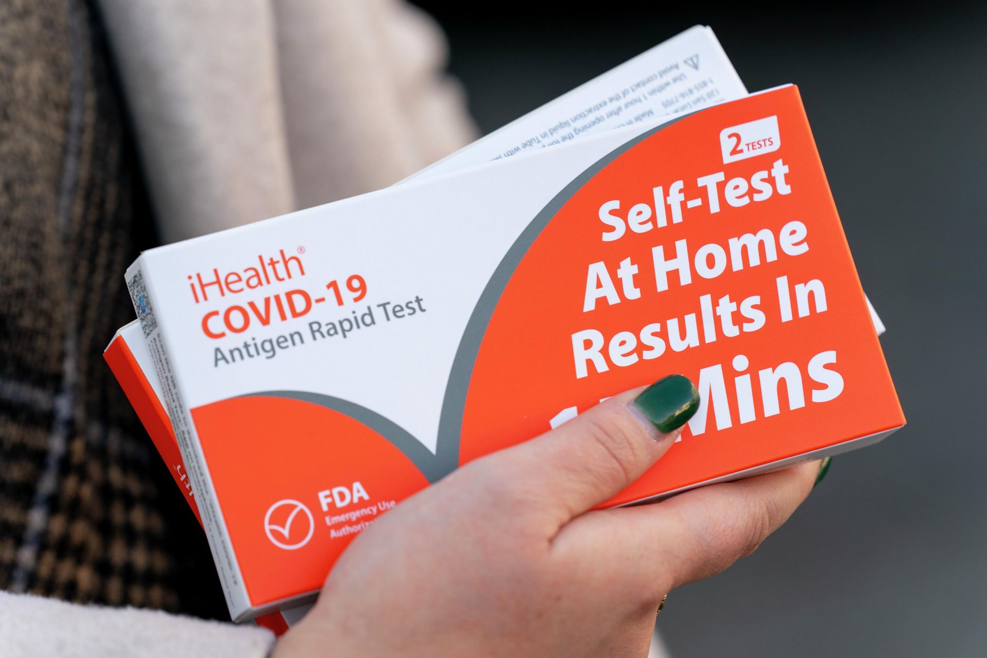 A woman holds two boxes of at-home Covid-19 test kits after waiting in a long line that snakes multiple times around the Shaw Library in Washington, Wednesday, Dec. 22, 2021 - Sputnik International, 1920, 19.09.2022
