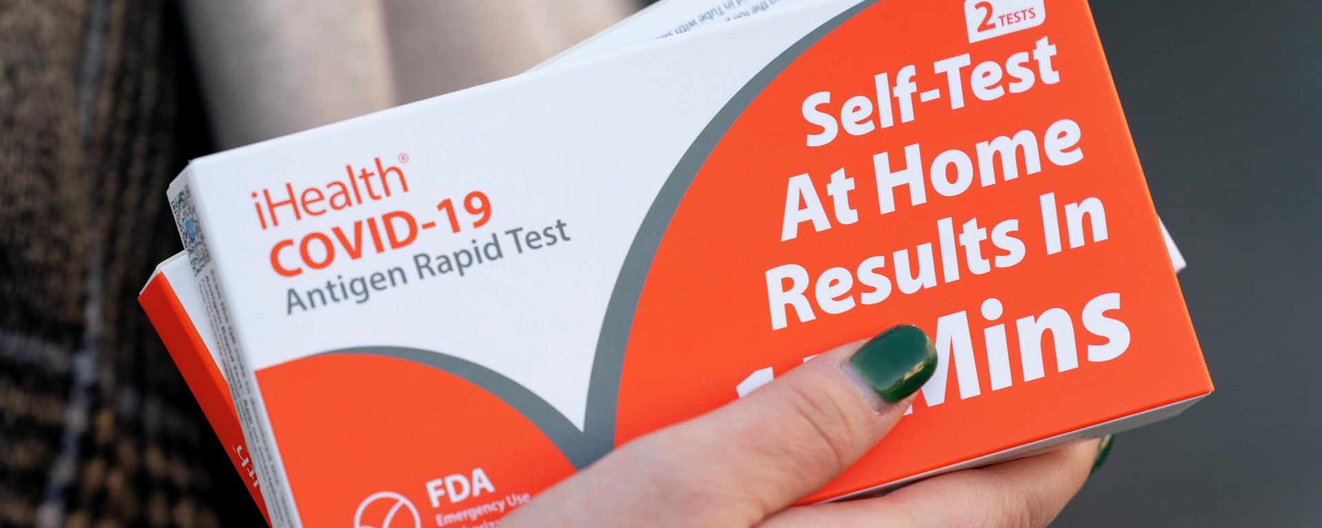 A woman holds two boxes of at-home Covid-19 test kits after waiting in a long line that snakes multiple times around the Shaw Library in Washington, Wednesday, Dec. 22, 2021 - Sputnik International, 1920, 28.12.2022