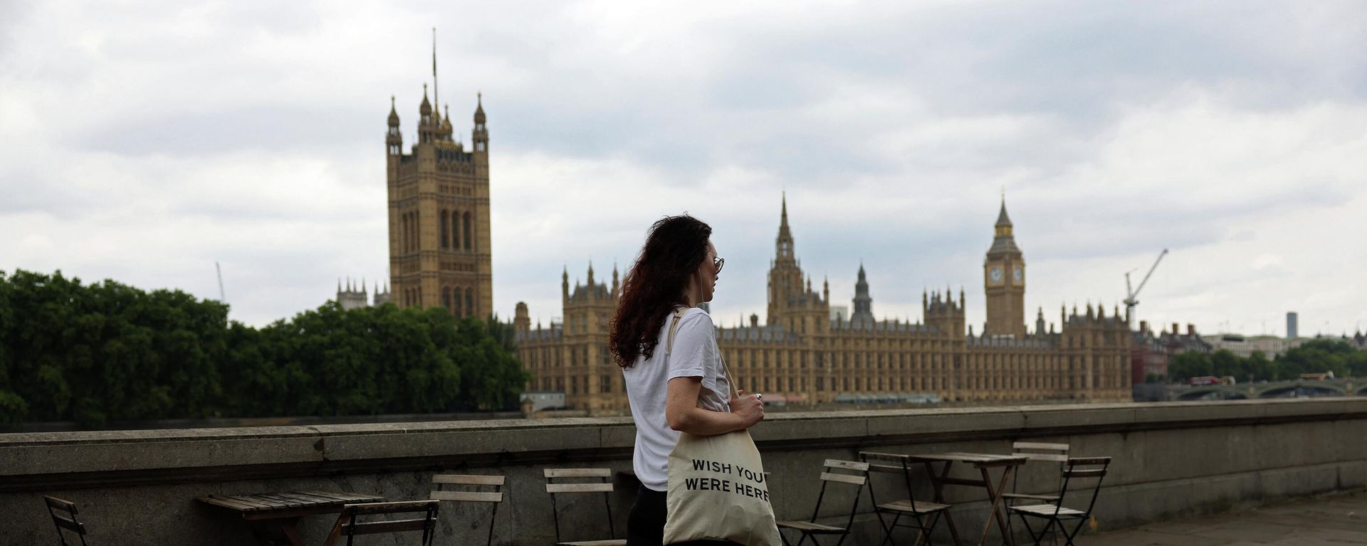 A pedestrian walks opposite The Palace of Westminster, Britain's Houses of Parliament - Sputnik International, 1920, 02.09.2022