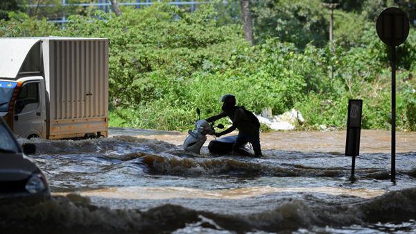 Motorists and vehicles wade through a street after heavy monsoon rains in Bangalore on September 5, 2022 - Sputnik International