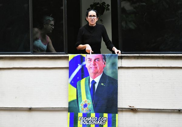A supporter of Brazilian President Jair Bolsonaro displays a banner of the president on a balcony before a motorcade rally and military parade to mark Brazil's 200th anniversary of independence, in Copacabana Beach in Rio de Janeiro, on September 7, 2022. - Sputnik International