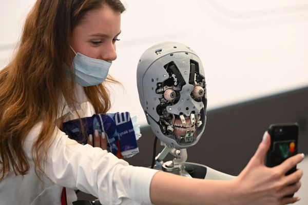 A participant of the Eastern Economic Forum in Vladivostok is photographed with the service robot-promoter Alex - Sputnik International