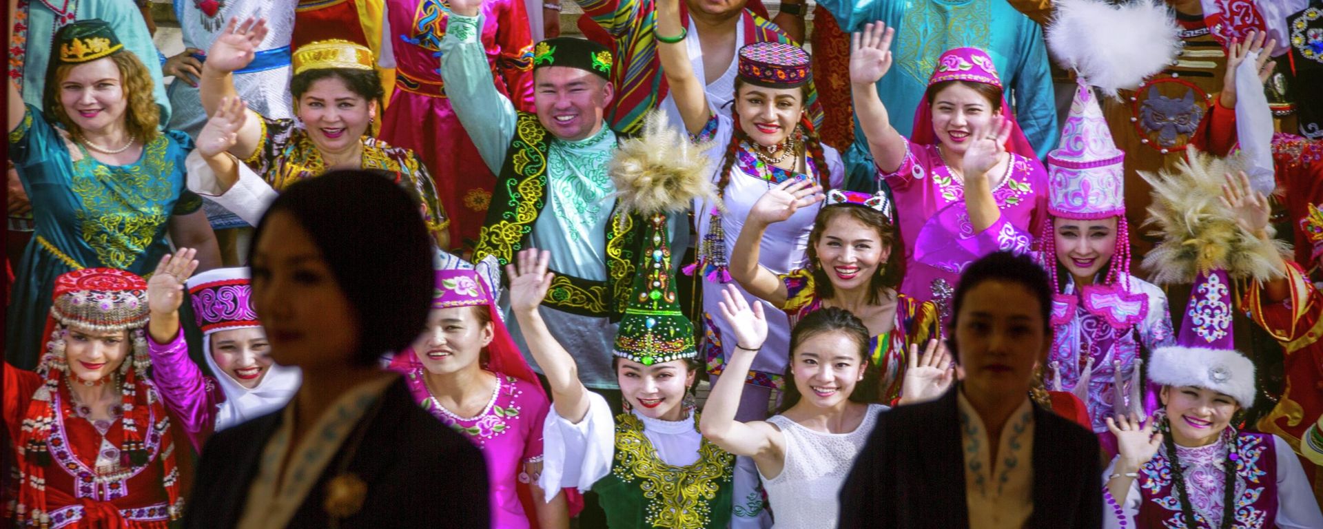 Tour guides stand in front of a large photo depicting different ethnic groups in Xinjiang at the Exhibition of the Fight Against Terrorism and Extremism in Urumqi in northwestern China's Xinjiang Uyghur Autonomous Region, as seen during a government organized visit, on April 21, 2021 Tour guides stand in front of a large photo depicting different ethnic groups in Xinjiang at the Exhibition of the Fight Against Terrorism and Extremism in Urumqi in northwestern China's Xinjiang Uyghur Autonomous Region, as seen during a government organized visit, on April 21, 2021 - Sputnik International, 1920, 08.09.2022