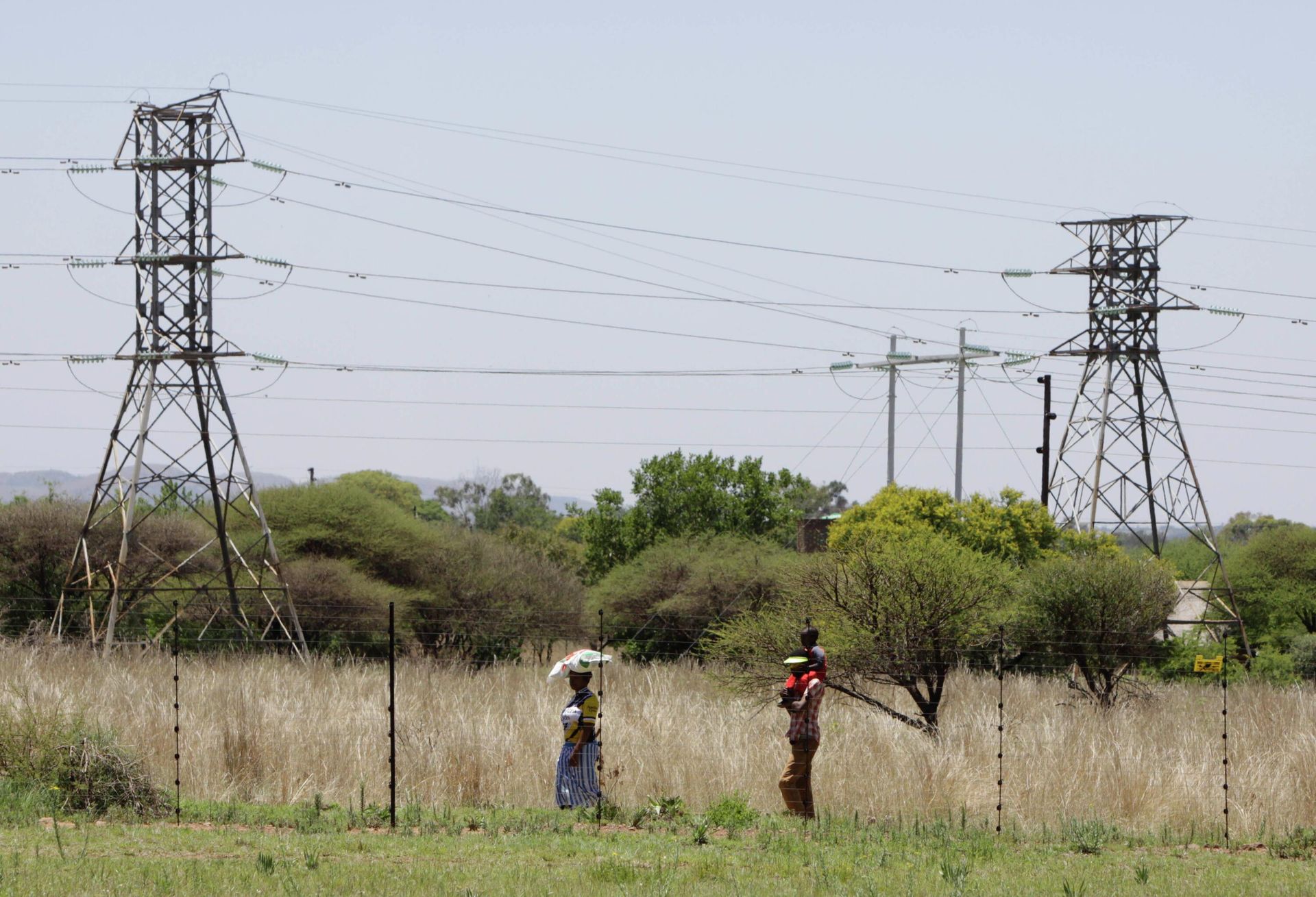 People walk below power pylons at Hartebeespoort, South Africa, Friday Nov. 25, 2011. Eskom is Africa's biggest power utility, accounting for more than 60 percent of all the electricity generated on the continent, according to the World Bank. It also exports across southern Africa. Critics and even supporters say Eskom should have started its move toward renewable sources of energy earlier, and now needs to set its ambitions higher. (AP Photo/Denis Farrell) People walk below power pylons at Hartebeespoort, South Africa, Friday Nov. 25, 2011. Eskom is Africa's biggest power utility, accounting for more than 60 percent of all the electricity generated on the continent, according to the World Bank. It also exports across southern Africa. Critics and even supporters say Eskom should have started its move toward renewable sources of energy earlier, and now needs to set its ambitions higher. (AP Photo/Denis Farrell) - Sputnik International, 1920, 13.11.2022