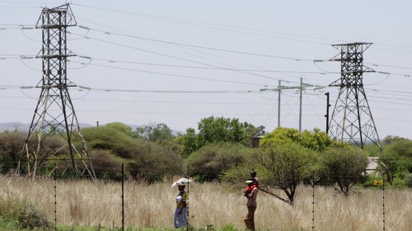 People walk below power pylons at Hartebeespoort, South Africa, Friday Nov. 25, 2011.  Eskom is Africa's biggest power utility, accounting for more than 60 percent of all the electricity generated on the continent, according to the World Bank. It also exports across southern Africa. Critics and even supporters say Eskom should have started its move toward renewable sources of energy earlier, and now needs to set its ambitions higher. (AP Photo/Denis Farrell) - Sputnik International
