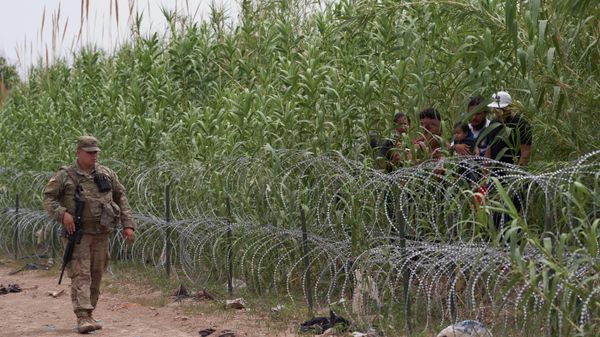 Migrants are apprehended by US Border Patrol and National Guard troops in Eagle Pass, Texas, on May 22, 2022.  - Sputnik International