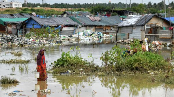A woman living in a slum wades through a waterlogged dwelling after heavy rains in Bangalore on September 7, 2022 - Sputnik International