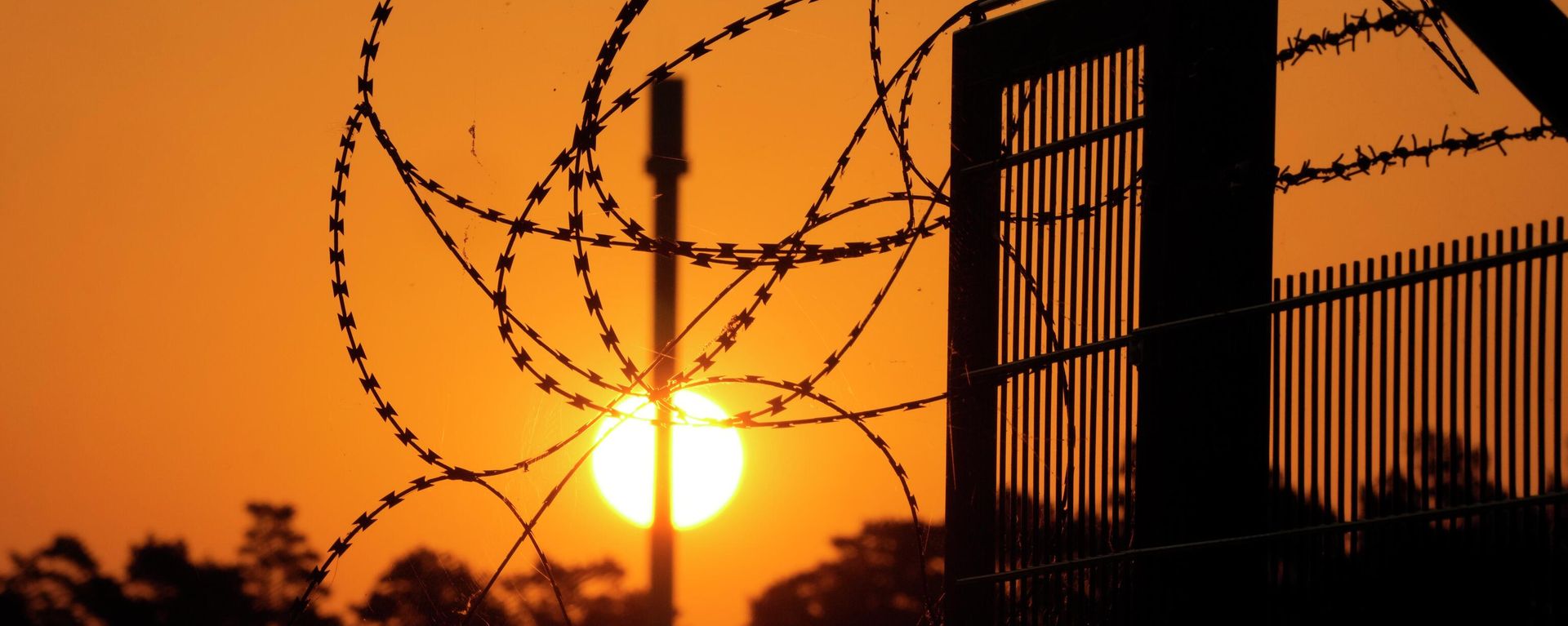 Barbed wir secure the entrance of the harbour area where the landfall of the Nord Stream 1 Baltic Sea pipeline located, as the sun rises behind the pipeline facility and the transfer station of the OPAL gas pipeline, the Baltic Sea Pipeline Link, in Lubmin, Germany, Thursday, July 21, 2022. Europe is bracing for the possibility that the key Nord Stream 1 pipeline that brings natural gas from Russia to Germany won't reopen as scheduled after routine maintenance. (AP Photo/Markus Schreiber) Barbed wir secure the entrance of the harbour area where the landfall of the Nord Stream 1 Baltic Sea pipeline located, as the sun rises behind the pipeline facility and the transfer station of the OPAL gas pipeline, the Baltic Sea Pipeline Link, in Lubmin, Germany, Thursday, July 21, 2022. Europe is bracing for the possibility that the key Nord Stream 1 pipeline that brings natural gas from Russia to Germany won't reopen as scheduled after routine maintenance. (AP Photo/Markus Schreiber) - Sputnik International, 1920, 26.09.2023