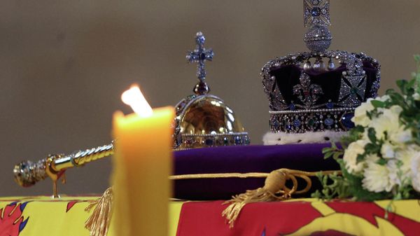 The coffin of Queen Elizabeth II, draped in the Royal Standard and adorned with the Imperial State Crown and the Sovereign's orb and sceptre, is pictured Lying in State inside Westminster Hall, at the Palace of Westminster in London on September 18, 2022 - Sputnik International