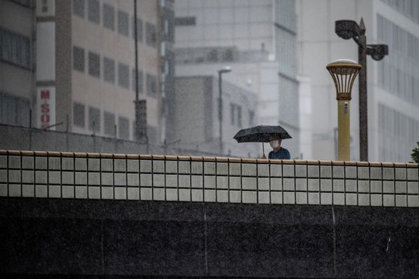 A man walks with an umbrella under heavy rain brought about by Typhoon Nanmadol, in Ueno district of Tokyo on September 18, 2022.  - Sputnik International