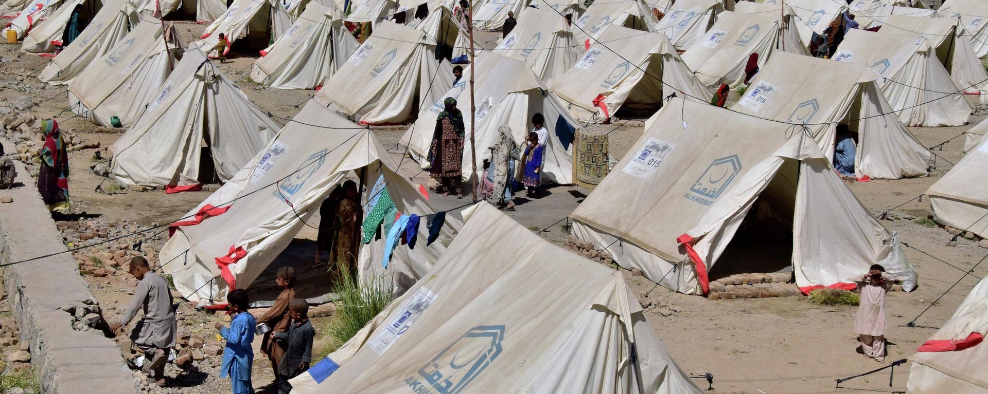 Victims of heavy flooding from monsoon rains stand beside their tents at a relief camp in Dasht near Quetta, Pakistan, Friday, Sept. 16, 2022. Victims of heavy flooding from monsoon rains stand beside their tents at a relief camp in Dasht near Quetta, Pakistan, Friday, Sept. 16, 2022. - Sputnik International, 1920, 19.09.2022