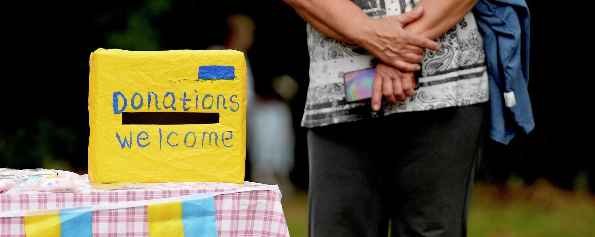 A woman waits near a donation box at the celebration for the Ukraine Independence day at a celebration in Chichester, south England, Saturday, Aug. 27, 2022 - Sputnik International, 1920, 22.10.2022