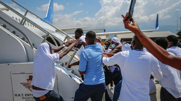 FILE - In this Sept. 21, 2021, file photo, Haitians deported from the United States try to board the same plane in which they were deported, in an attempt to return to the United States, on the tarmac of the Toussaint Louverture airport in Port-au-Prince, Haiti. The Border Patrol's treatment of Haitian migrants, they say, is just the latest in a long history of discriminatory U.S. policies and of indignities faced by Black people, sparking new anger among Haitian Americans, Black immigrant advocates and civil rights leaders.(AP Photo/Odelyn Joseph, File) - Sputnik International