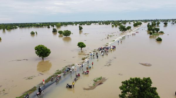 People walk through floodwaters after heavy rainfall in Hadeja, Nigeria, Monday, Sept 19, 2022. Nigeria is battling its worst floods in a decade with more than 300 people killed in 2021 including at least 20 this week, authorities told the Associated Press on Monday. - Sputnik International