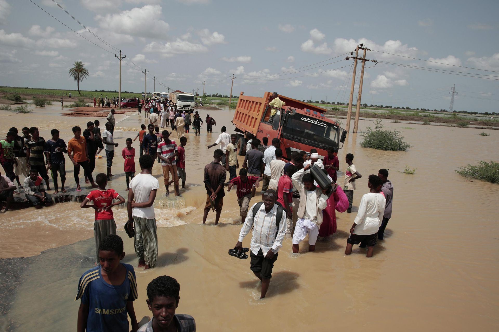 People walk on a flooded road after a heavy rainfall in the village of Aboud in the El-Manaqil district of the Al-Jazirah province, southeast of Khartoum, Sudan, Monday, August 22 2022. People walk on a flooded road after a heavy rainfall in the village of Aboud in the El-Manaqil district of the Al-Jazirah province, southeast of Khartoum, Sudan, Monday, August 22 2022. - Sputnik International, 1920, 20.09.2022