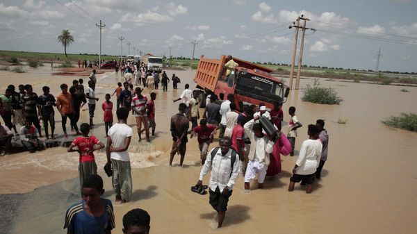 People walk on a flooded road after a heavy rainfall in the village of Aboud in the El-Manaqil district of the Al-Jazirah province, southeast of Khartoum, Sudan, Monday, August 22 2022. - Sputnik International