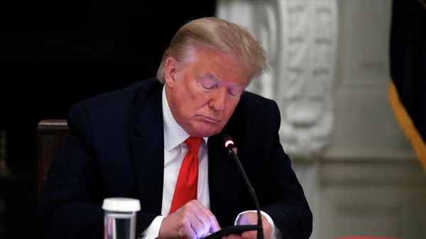President Donald Trump looks at his phone during a roundtable with governors on the reopening of America's small businesses, in the State Dining Room of the White House in Washington, June 18, 2020 - Sputnik International