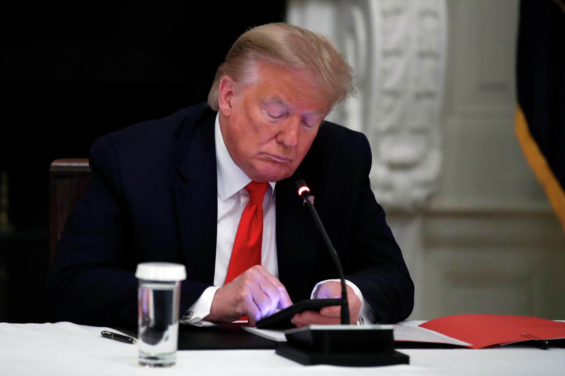 President Donald Trump looks at his phone during a roundtable with governors on the reopening of America's small businesses, in the State Dining Room of the White House in Washington, June 18, 2020 President Donald Trump looks at his phone during a roundtable with governors on the reopening of America's small businesses, in the State Dining Room of the White House in Washington, June 18, 2020 - Sputnik International, 1920, 15.11.2022
