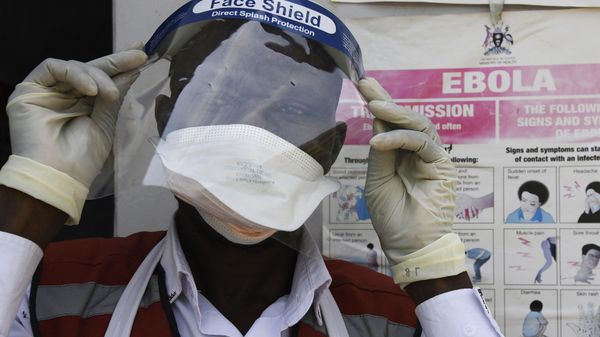 A health worker puts on protective gears as he prepares to screen travellers at the Mpondwe Health Screening Facility in the Uganda's border town of Mpondwe as they cross over from the Democratic Republic of Congo, on June 13, 2019. - Sputnik International