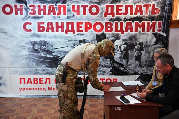 A member of a volunteer detachment at a polling station in Melitopol during the referendum on accession to Russia of the Zaporozhye region. - Sputnik International