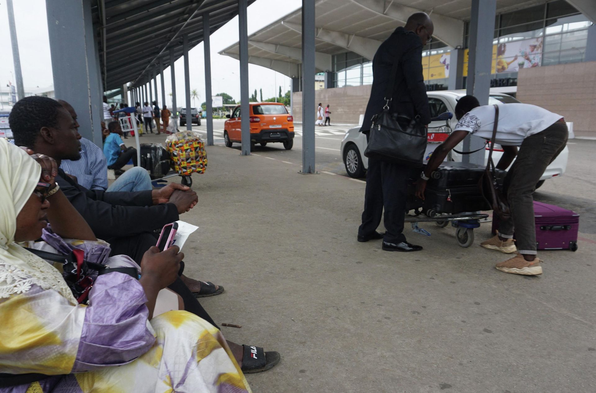 People wait by their luggage outside the Felix Houphouet Boigny International airport in Abidjan on September 24, 2022, after a strike by air traffic controllers, that started Friday, paralysed serval West African airports with all commercial flights cancelled. (Photo by Issouf SANOGO / AFP) People wait by their luggage outside the Felix Houphouet Boigny International airport in Abidjan on September 24, 2022, after a strike by air traffic controllers, that started Friday, paralysed serval West African airports with all commercial flights cancelled. (Photo by Issouf SANOGO / AFP) - Sputnik International, 1920, 25.09.2022