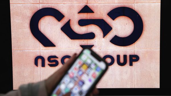 A photographic illustration shows a mobile phone near the NSO Group company logo on February 9, 2022 in the Israeli city of Netanya. - Sputnik International