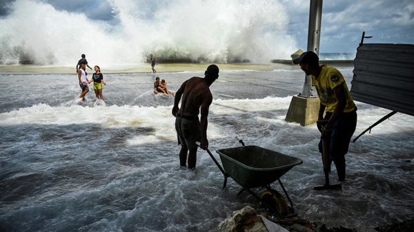 Community workers collect debris while children play near the Malecon in Havana, on September 29, 2022, after the passage of hurricane Ian - Sputnik International