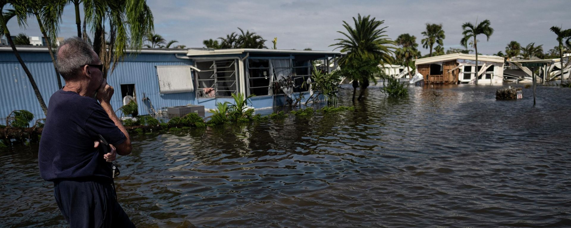 A man looks on from the a flooded street of a neighborhood in Fort Myers, Florida on September 29, 2022. - Hurricane Ian left much of coastal southwest Florida in darkness early on Thursday, bringing catastrophic flooding that left officials readying a huge emergency response to a storm of rare intensity. A man looks on from the a flooded street of a neighborhood in Fort Myers, Florida on September 29, 2022. - Hurricane Ian left much of coastal southwest Florida in darkness early on Thursday, bringing catastrophic flooding that left officials readying a huge emergency response to a storm of rare intensity. - Sputnik International, 1920, 01.10.2022