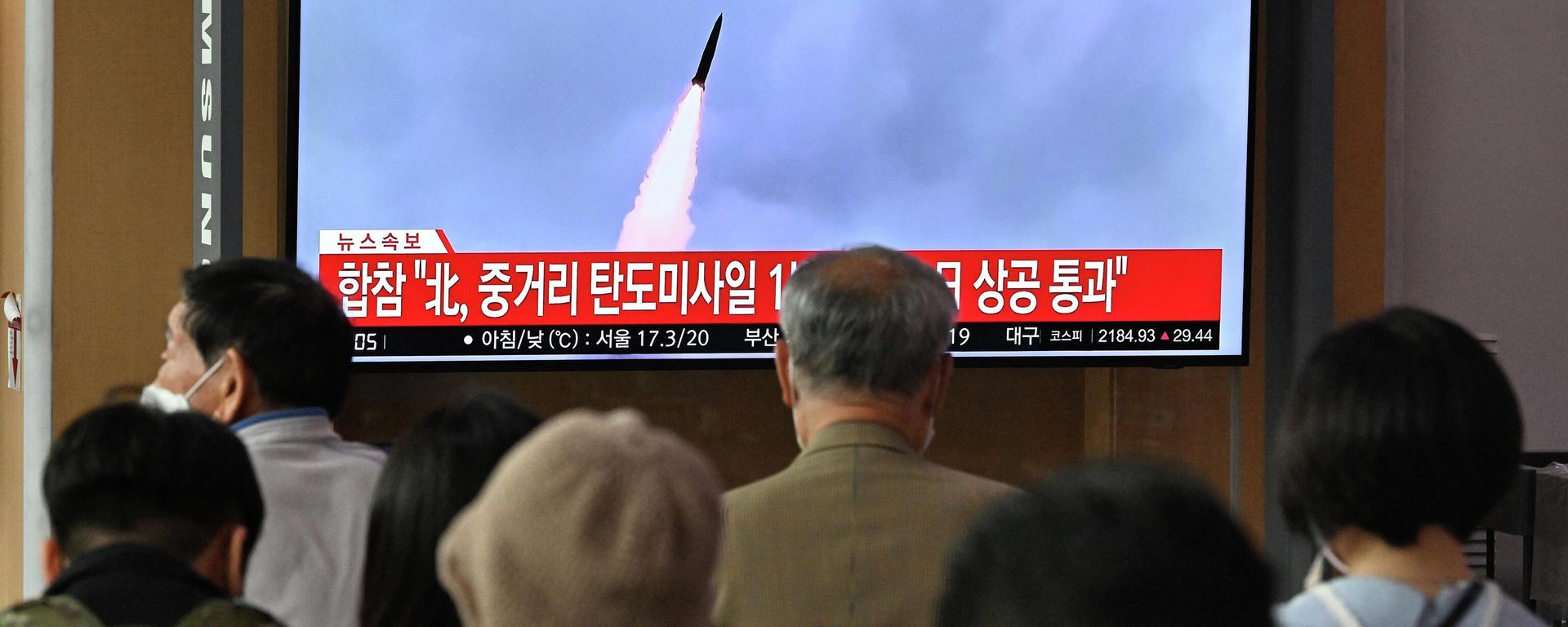 People watch a television screen showing a news broadcast with file footage of a North Korean missile test, at a railway station in Seoul on October 4, 2022 - Sputnik International, 1920, 26.10.2022