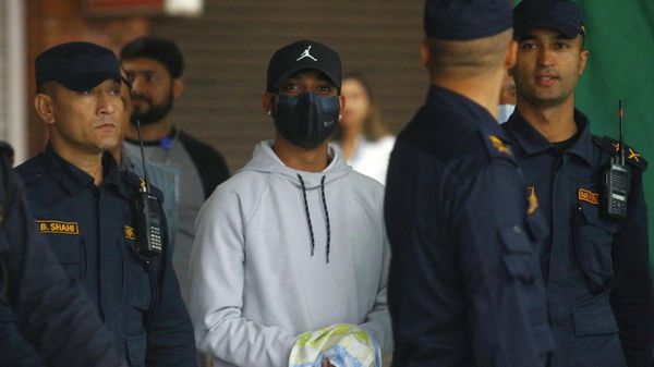 Nepali cricketer Sandeep Lamichhane (C) is escorted by police after being taken into custody to face rape charges, at Tribhuvan international airport in Kathmandu on October 6, 2022.  - Sputnik International