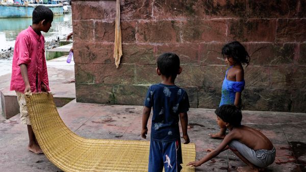 Homeless children spread a mat under the shade of a rail bridge on the bank of Hooghly River in Kolkata, India, Monday, May 23, 2022. - Sputnik International