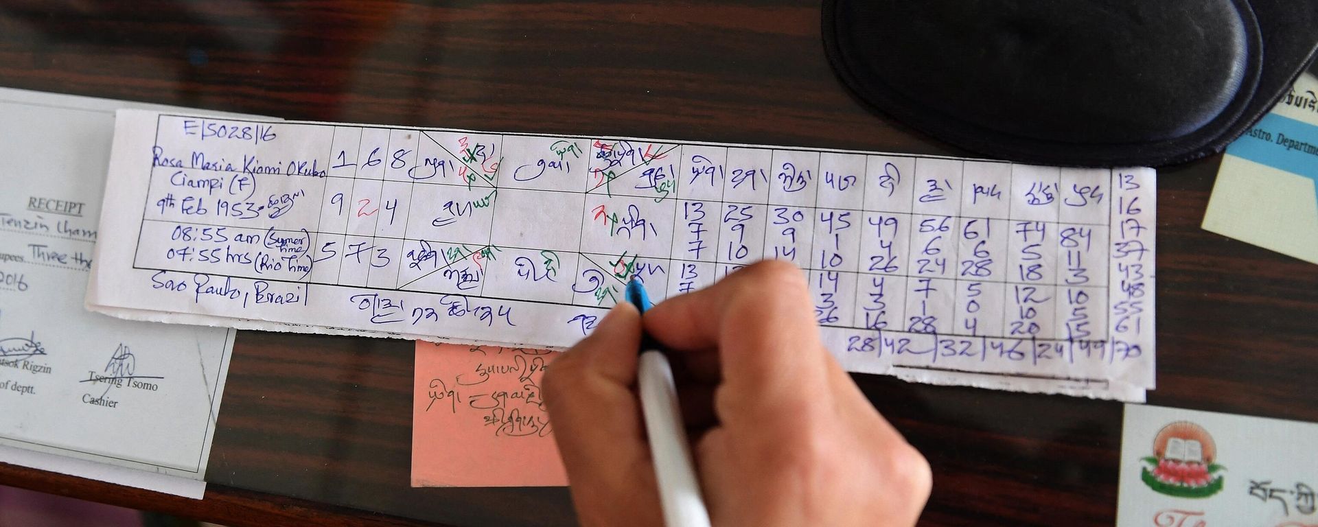 In this photograph taken on March 23, 2017, Tibetan astrologer Tenzin Tsundue writes a horoscope at the Gangkyi Men-Tsee Khang clinic in the Indian town of Dharamsala. In this photograph taken on March 23, 2017, Tibetan astrologer Tenzin Tsundue writes a horoscope at the Gangkyi Men-Tsee Khang clinic in the Indian town of Dharamsala. - Sputnik International, 1920, 10.10.2022