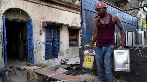 A laborer unloads cans of edible oil from a truck in Prayagraj, India, Tuesday, May 24, 2022. - Sputnik International