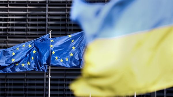 Flags of the European Union and Ukraine outside the European Council headquarters in Brussels. - Sputnik International