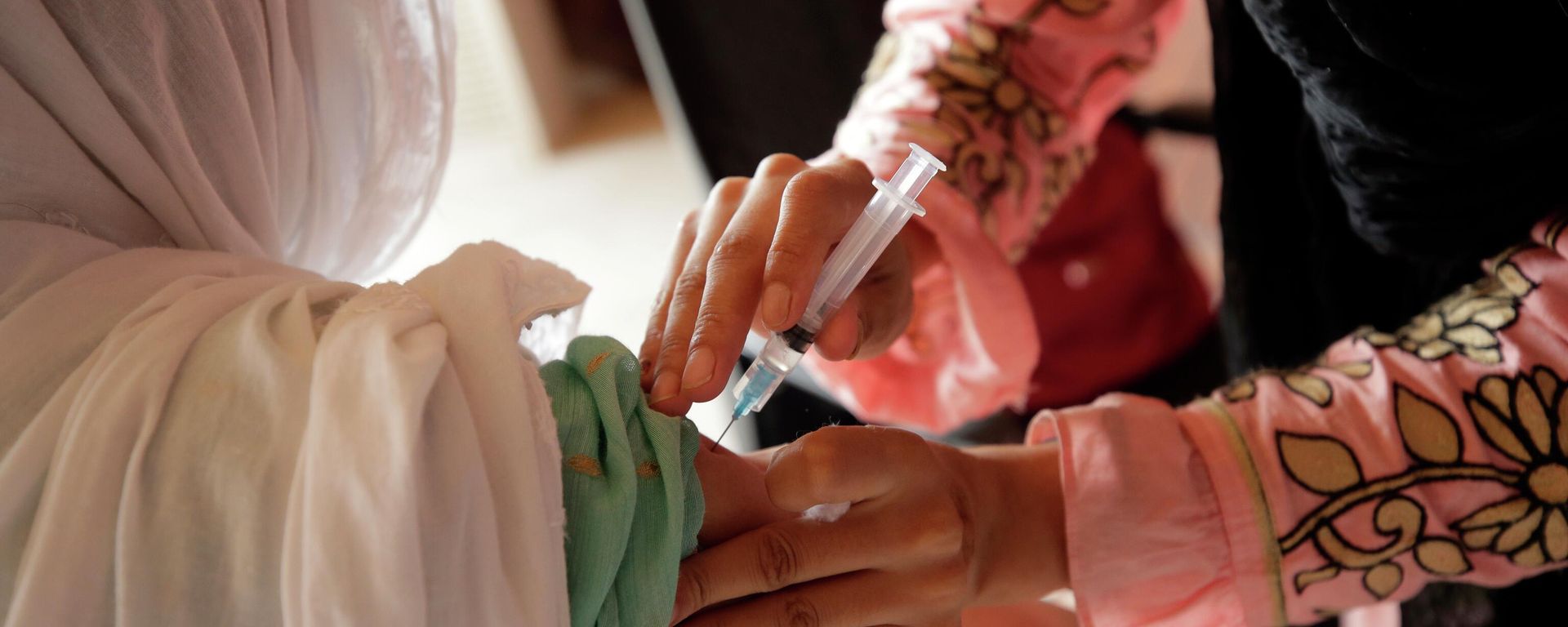 A woman receives the Sinopharm COVID-19 vaccine from a health worker at a vaccination center in Islamabad, Pakistan, Monday, Oct. 4, 2021. - Sputnik International, 1920, 19.10.2022