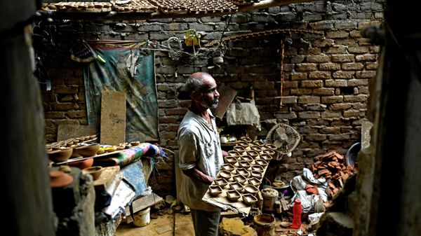 A potter lays out earthen lamps on a tray ahead of the Hindu festival of ‘Diwali’ in New Delhi on October 17, 2022. - Sputnik International
