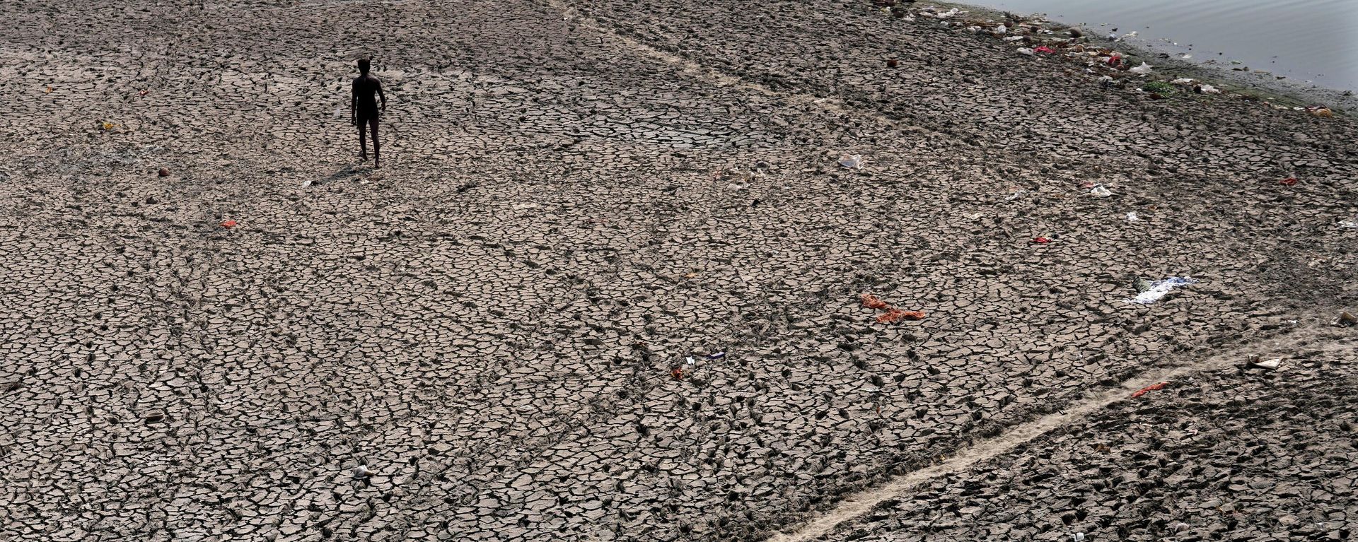 A man walks across a dried bed of river Yamuna where water levels have reduced drastically following hot weather in New Delhi, India, Monday, May 2, 2022. A man walks across a dried bed of river Yamuna where water levels have reduced drastically following hot weather in New Delhi, India, Monday, May 2, 2022. - Sputnik International, 1920, 21.10.2022
