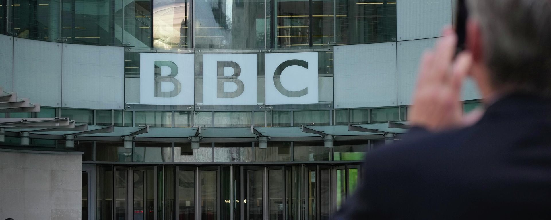 A man takes a photo of the BBC Headquarters in London, Tuesday, Oct. 18, 2022 as the BBC celebrates 100 years of broadcasting. - Sputnik International, 1920, 21.10.2022