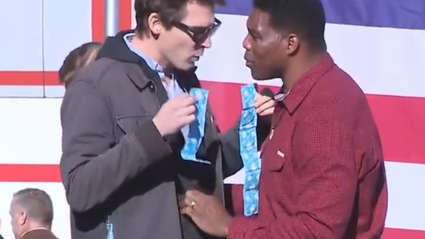 Comedian Jason Selvig of The Good Liars confronts US Senate candidate Herschel Walker with a pack of condoms. - Sputnik International