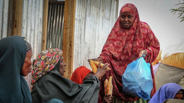 Somalis who fled drought-stricken areas receive charitable food donations from city residents after arriving at a makeshift camp for the displaced on the outskirts of Mogadishu, Somalia on June 30, 2022 - Sputnik International