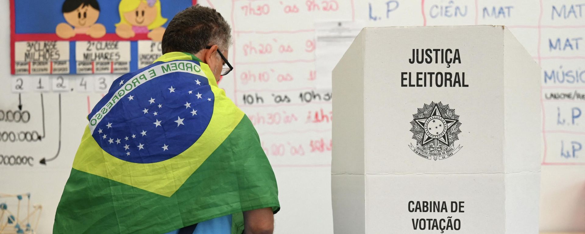 A man with a Brazilian national flag on his shoulders votes at a polling station in Brasilia, on October 30, 2022, during the presidential run-off election. A man with a Brazilian national flag on his shoulders votes at a polling station in Brasilia, on October 30, 2022, during the presidential run-off election. - Sputnik International, 1920, 22.11.2022