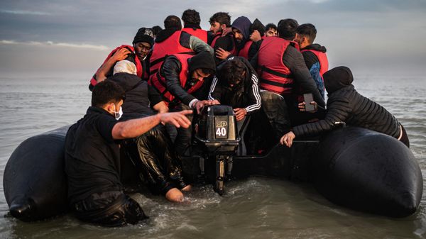 Migrants try to start an outboard engine after boarding a smuggler's boat on the beach of Gravelines, near Dunkirk, northern France on October 12, 2022, in a attempt to cross the English Channel - Sputnik International