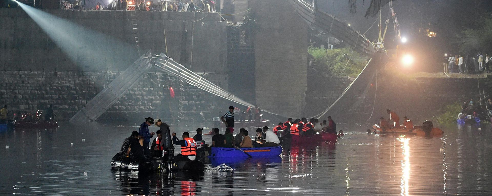 Indian rescue personnel conduct search operations after a bridge across the river Machchhu collapsed in Morbi, some 220 kms from Ahmedabad, early on October 31, 2022 Indian rescue personnel conduct search operations after a bridge across the river Machchhu collapsed in Morbi, some 220 kms from Ahmedabad, early on October 31, 2022 - Sputnik International, 1920, 31.10.2022