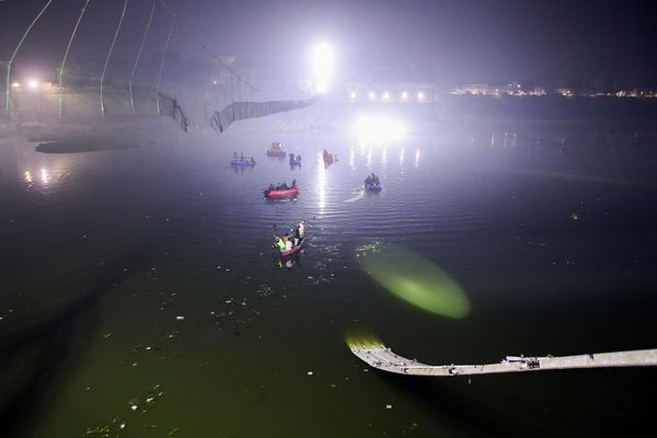 Indian rescue personnel conduct search operations after a bridge across the Machchhu River collapsed in Morbi, some 220 km from Ahmedabad, early on October 31, 2022. At least 75 people were killed on October 30 in India after an almost 150-year-old colonial-era pedestrian bridge collapsed, sending scores of people tumbling into the river below. - Sputnik International