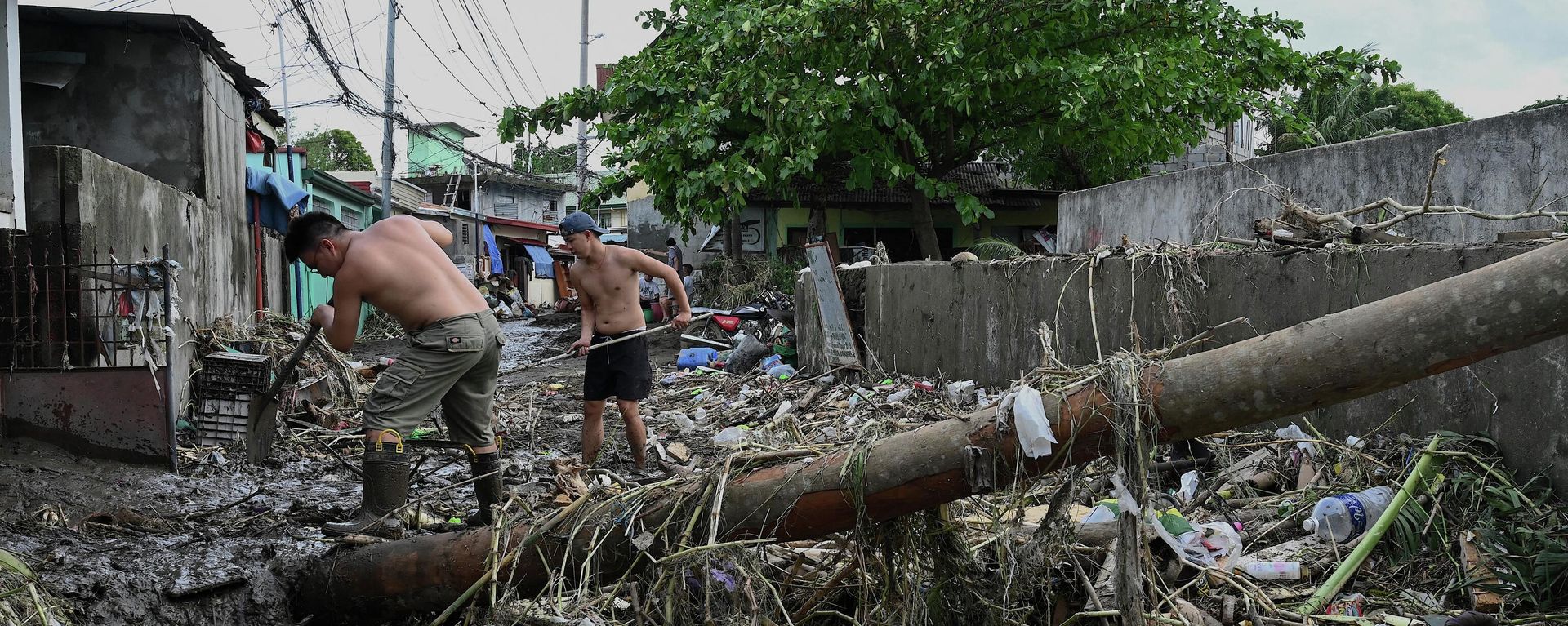 Men clean the debris along a debris-covered street in Noveleta, Cavite province on October 30, 2022, a day after Tropical Storm Nalgae hit. - Men clean the debris along a debris-covered street in Noveleta, Cavite province on October 30, 2022, a day after Tropical Storm Nalgae hit. - - Sputnik International, 1920, 01.11.2022