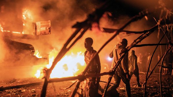 People walk by U.N. vehicles which were set on fire, in Goma, Democratic Republic of Congo, Tuesday Nov. 1, 2022. - Sputnik International