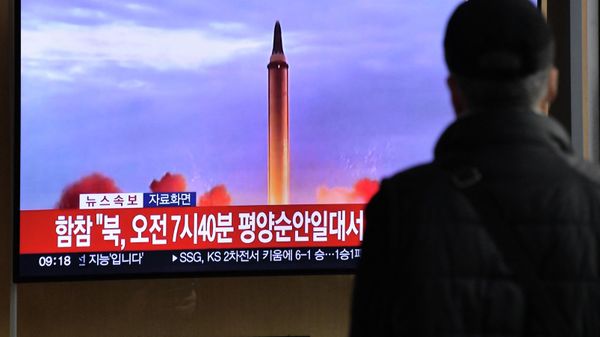 A man watches a television screen showing a news broadcast with file footage of a North Korean missile test, at a railway station in Seoul on November 3, 2022 - Sputnik International