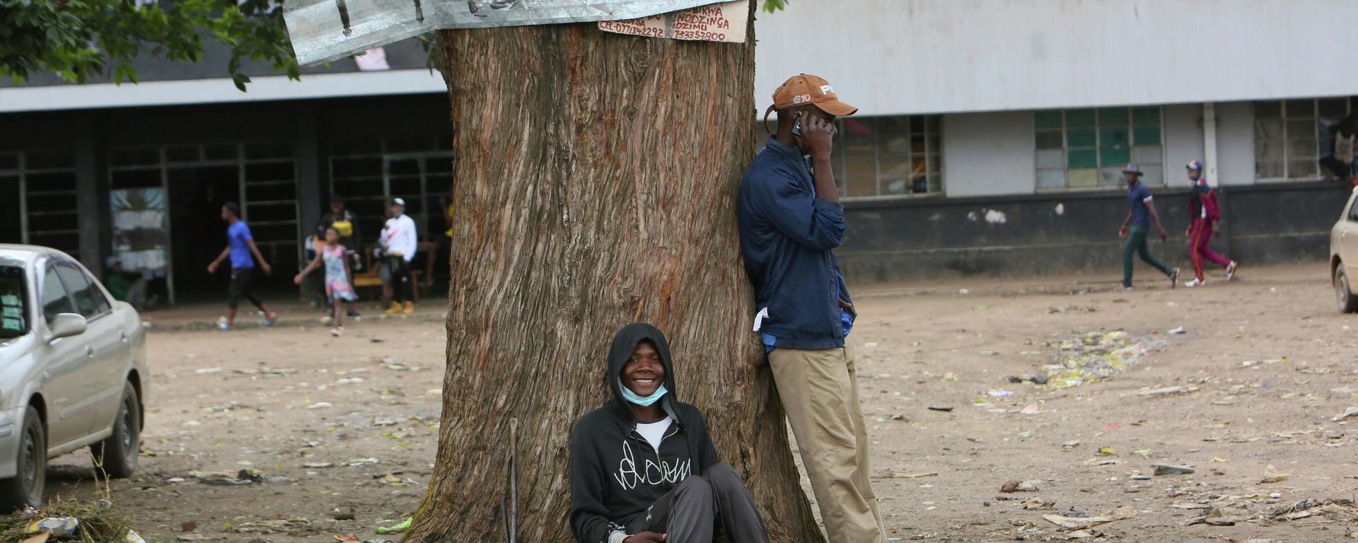 Two men relax under a tree in a poor township on the outskirts of the capital Harare, Tuesday, Nov, 16, 2021.  - Sputnik International, 1920, 10.11.2022