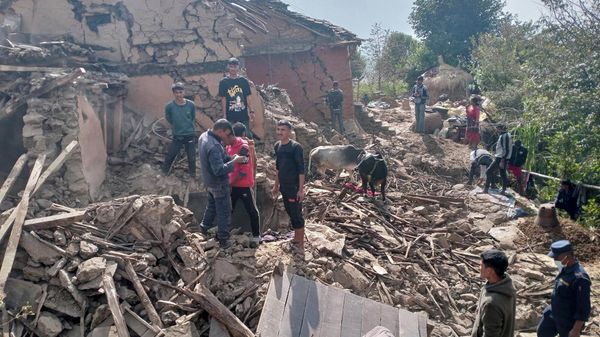 Nepalese villagers stand amidst the debris of their mudhouses after an earthquake in Doti district, Nepal, Wednesday, Nov.9, 2022. - Sputnik International